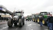 Szene auf einer Demonstration mit Traktoren, die eine Straße blockieren. © Screenshot 