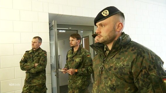Drei Bundeswehrsoldaten bei einer Einsatzbesprechung. © Screenshot 