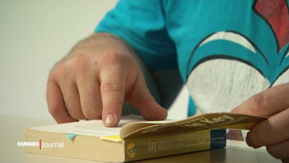Ein junger Mann liest in einem Buch. © Screenshot 