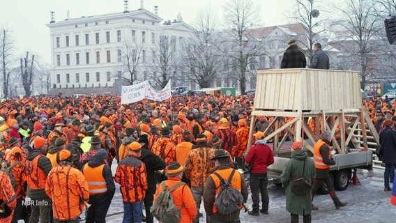 Viele überwiegend orange gekleidete Menschen bei einer Kundgebung. © Screenshot 