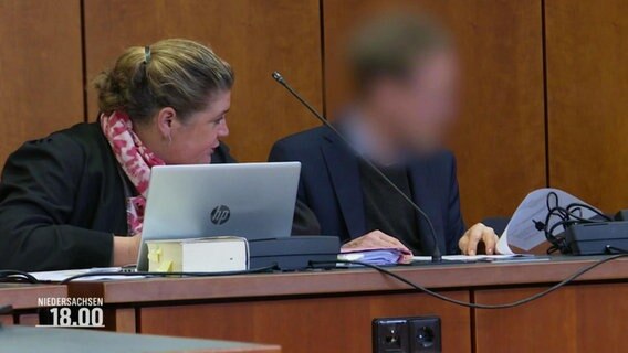 Ein Angeklagter sitzt in einem Gerichtssaal neben seiner Verteidigerin. © Screenshot 