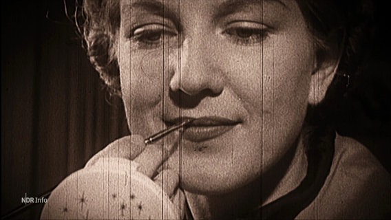 Bild aus einem Schwarzweiß-Film: Eine Frau schminkt sich die Lippen. © Screenshot 