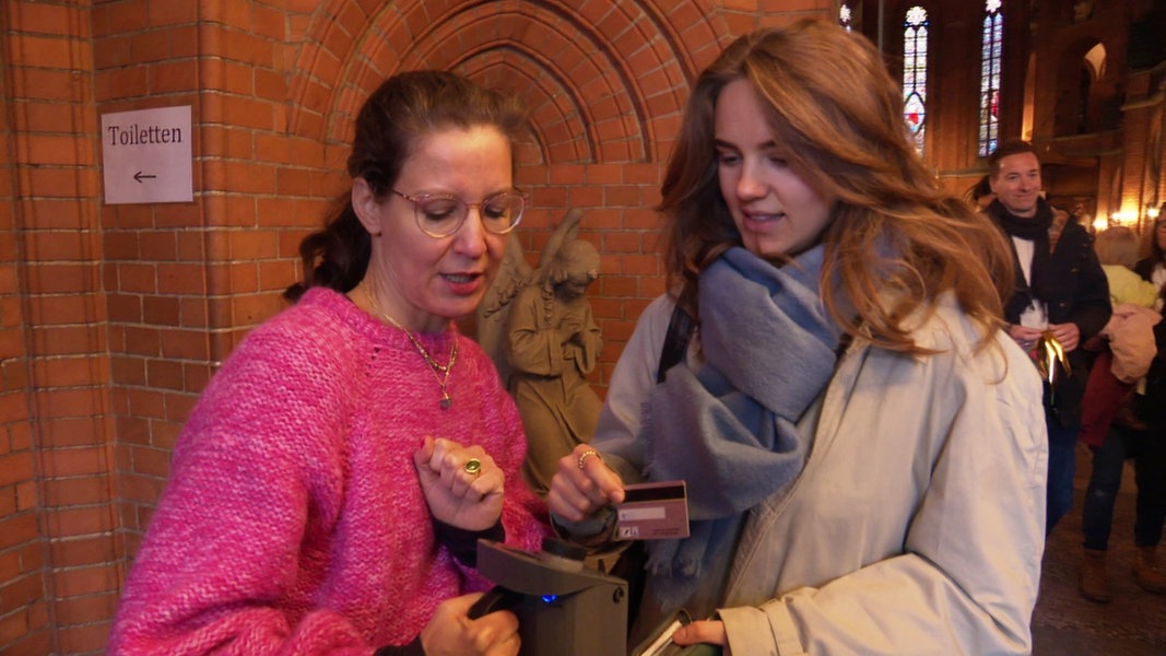 Eine Frau überweist nach dem Gottesdienst die Kollekte mit ihrer EC-Karte.