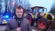 Reporter Denis Mollenhauer vor einem Traktorkonvoi. © Screenshot 