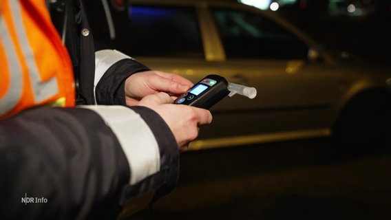 Eine Person hält einen Alkoholtester in der Hand. © Screenshot 