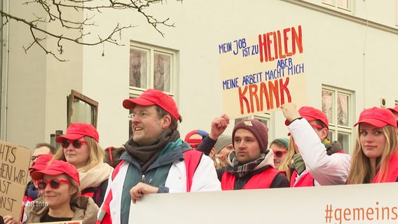 Ärztinnen und Ärzte streiken vor einem Uni-Klinikum. © Screenshot 