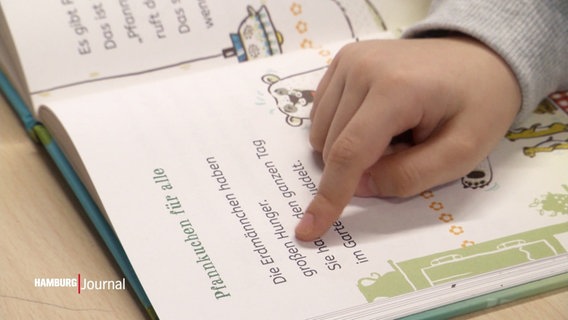 Ein Kind liest in einem Schulbuch. © Screenshot 