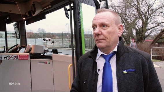 Ein Mann mit "Rebus"-Uniform steht nehmen einem Linienbus © Screenshot 