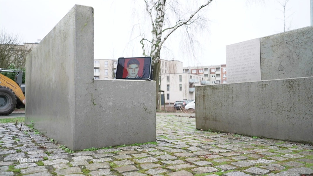 Vor einer Gedenktafel steht ein Tablet, das ein Foto des NSU-Opfers Mehmet Turgut zeigt.
