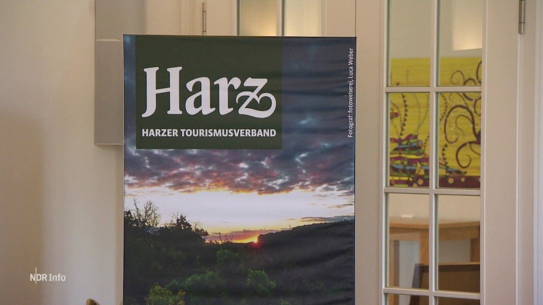 Ein Aufsteller des Harzer Tourismusverbands steht vor einer Tür.
