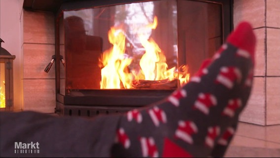 Jemand wärmt sich die Füße am Kaminfeuer. © Screenshot 
