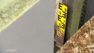 Am Gewässerrand ist eine Skala zur Messung des Pegelstands angebracht. © Screenshot 