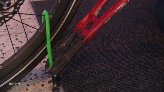 Ein Fahrradschloss wird mit einem Bolzenschneider geöffnet. © Screenshot 