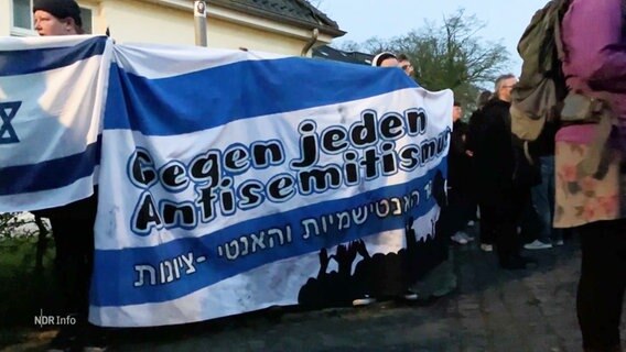 Eine Gruppe mit einem Banner auf dem "Gegen jeden Antisemitismus" steht. © Screenshot 