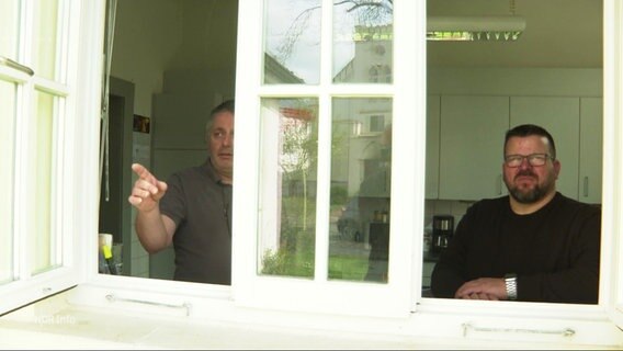 Olaf Alves und Andreas Erburt am Fenster ihres Hausmeisterbüros. © Screenshot 