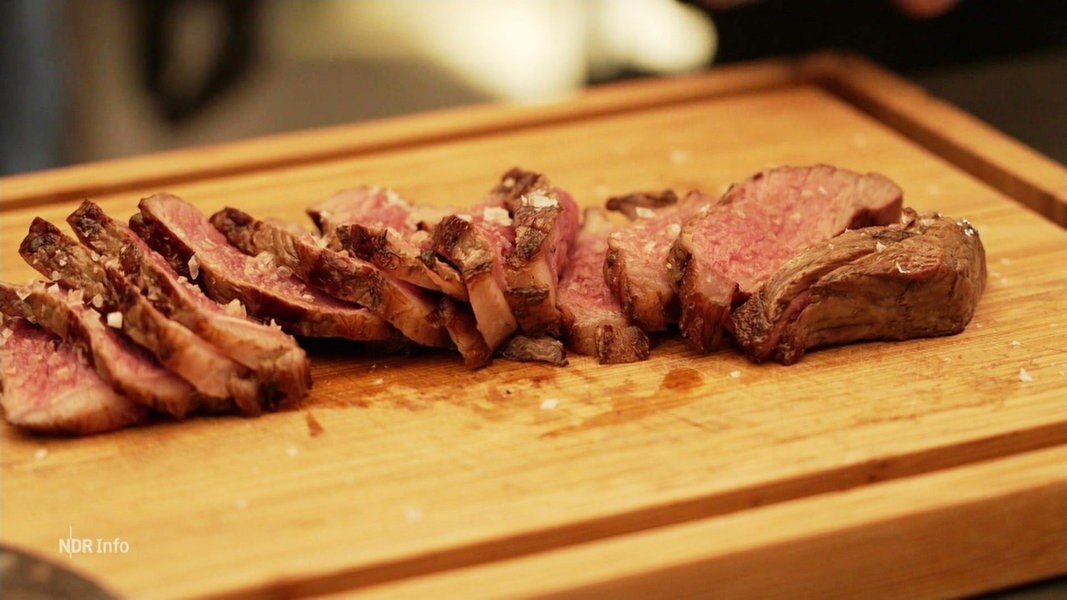 Ein Steak liegt geschnitten auf einem Brett.