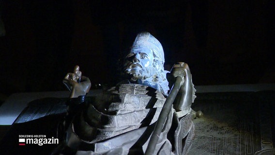 Die Statue des Bischofs Bockholt wird im Lübecker Dom bei einer abendlichen Führung mit einer Taschenlampe angeleuchtet. © Screenshot 