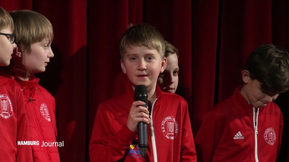 Kinder aus der Fußballmannschaft von KS Polonia vor einem roten Vorhang. © Screenshot 