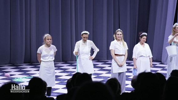 Das Ensemble des Staatstheaters steht in weißen Kostümen auf der Bühne. © Screenshot 