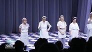 Das Ensemble des Staatstheaters steht in weißen Kostümen auf der Bühne. © Screenshot 