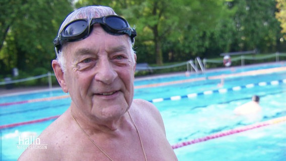 Ein älterer Herr mit Schwimmbrille in einem Freibad. © Screenshot 