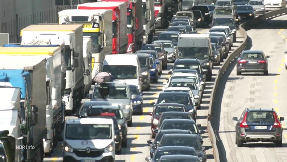 Auf einer Autobahn stauen sich Autos und Lastwagen. © Screenshot 