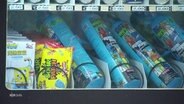Mehrere Dosen mit Lach·gas liegen in einem Automaten. Der Automat hat auch Süßigkeiten. © Screenshot 