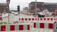 Rot-weiße Schrankenzäune einer Baustelle auf einer Kreuzung in Lübeck. © Screenshot 