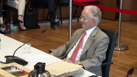Staatskanzleichef Jörg Mielke bei der Befragung. Er sitzt an einem Tisch, vor ihm ein Mikrofon und ein Stapel Dokumente. © Screenshot 