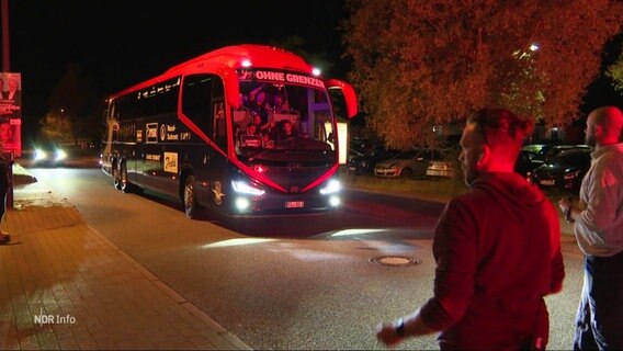 Ein rot-schwarzer Bus fährt auf einen Parkplatz. © Screenshot 