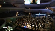 Musiker*innen und Sänger*innen proben eine Oper in der Elbphilharmonie © Screenshot 