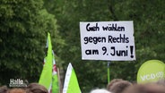 "Geh wählen gegen Rechts am 9. Juli!", steht auf einem Schild, das bei einer Demonstration hochgehalten wird. © Screenshot 