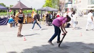 Auf einem Platz macht ein Jugendlicher gekonnte Tricks mit seinem Skateboard. © Screenshot 