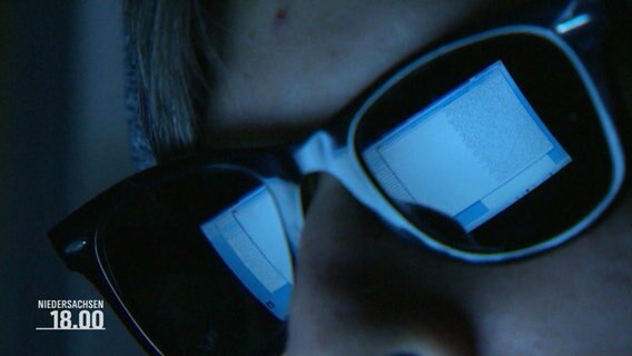Ein Hacker mit Sonnenbrille in einem dunklen Raum vor einem Rechner © Screenshot 
