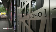 Eingangstür des Clubs "Noho". Sie ist mit einem Edelstahlgitter mit eingeprägtem Logo verziehrt. © Screenshot 