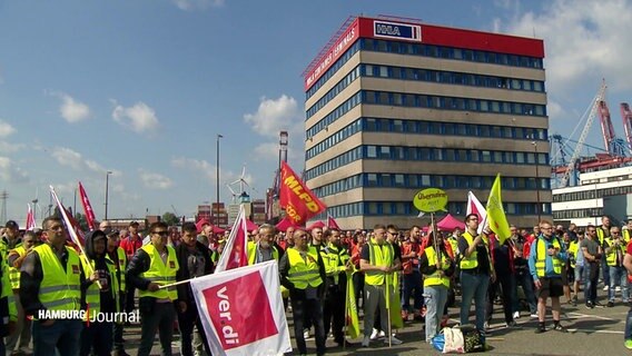 Demonstrierende mit Warnwesten und Fahnen. © Screenshot 