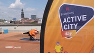 Ein Banner mit der Aufschrift "active city day", dahinter eine Person, die Yoga macht und die Hamburger Skyline. © Screenshot 