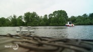 Auf einem kleineren Fluss fährt ein Motorboot im Hintergrund. © Screenshot 
