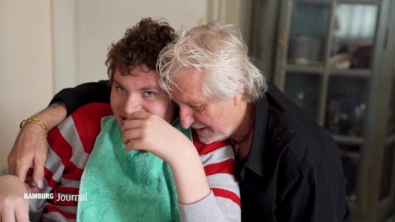 Arnold Schnittger umarmt seinen Sohn Nico, dieser sitzt in einem Rollstuhl. © Screenshot 