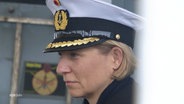 Fregattenkapitän Bianca Seifert bei der Arbeit. Sie trägt Uniform und hat ihre kurzen blonden Haareinter die Ohren gesteckt. © Screenshot 