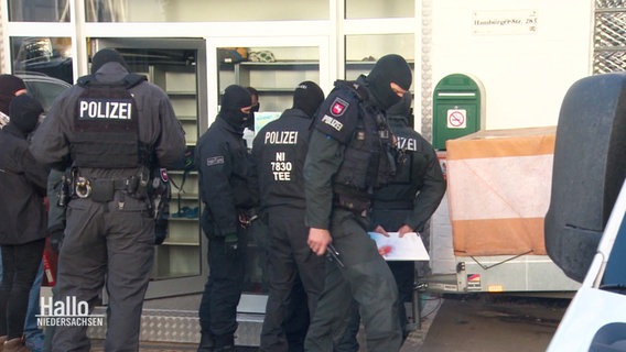 Polizei-Einsatzkräfte in schwarzer Uniform während der Razzia. © Screenshot 