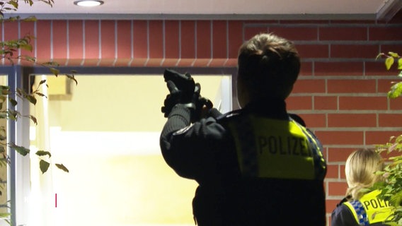 Ein Polizist mit gezogenener Waffe © Screenshot 
