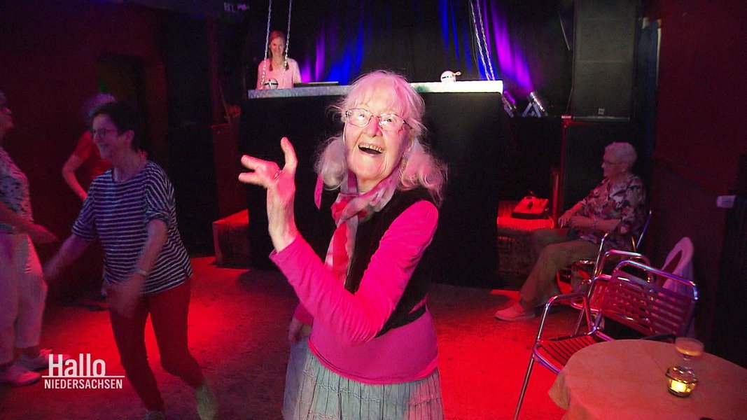 Eine Seniorin tanzt in einer Disco.