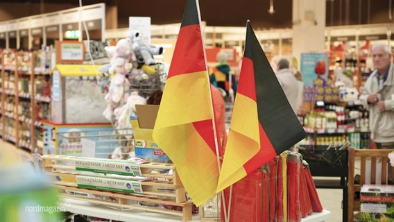 Deutschland-Fähnchen stehen in einem Laden. © Screenshot 