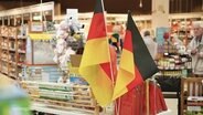 Deutschland-Fähnchen stehen in einem Laden. © Screenshot 