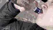 In einer nachgestellten Szene trinkt ein Mann direkt aus einer Flasche Vodka. © Screenshot 