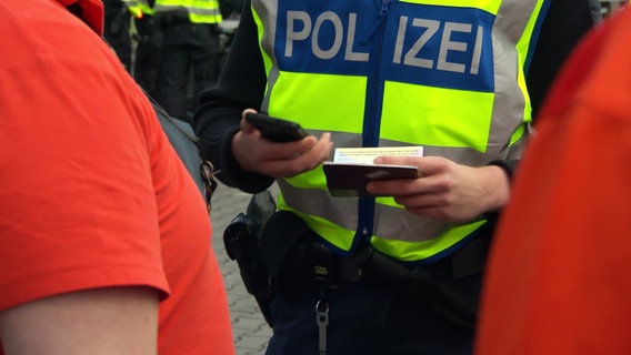 Oberkörper einer Person, auf der Brust ist das Wort Polizei zu sehen. © Screenshot 