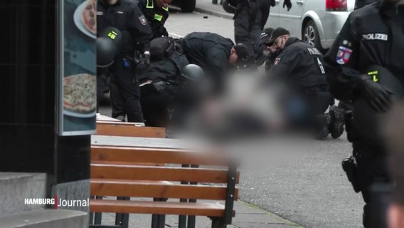 Mehrere Polizisten halten eine Person am Boden fest © Screenshot 