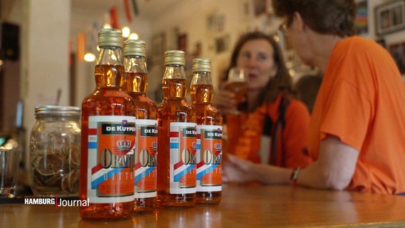 Mehrere Flaschen Oranje-Schnaps stehen auf einem Tresen © Screenshot 