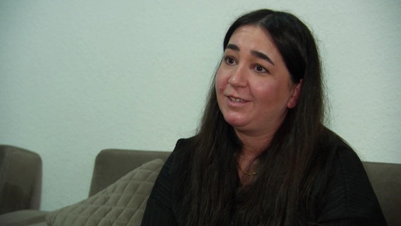 Familienbegleiterin Aishe Yilmaz im Interview. Sie trägt eine schwarze Bluse und hat langes, offenes braunes Haar. © Screenshot 